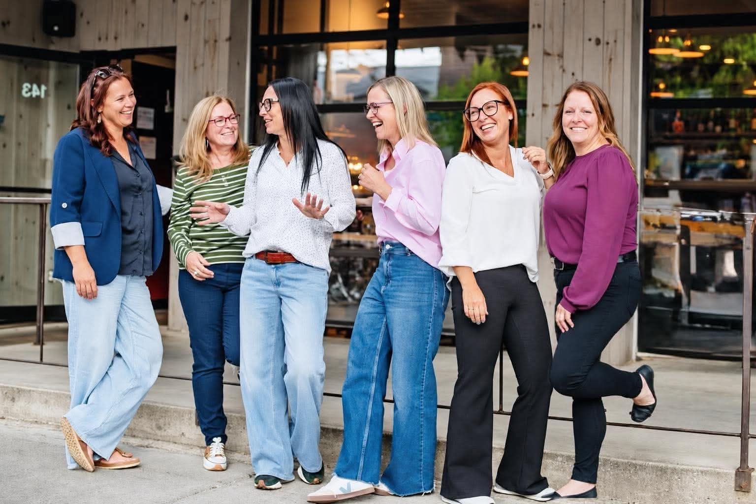 Les six organisatrices du Salon de la femme en Abitibi-Témiscamingue qui rient ensemble devant un restaurant